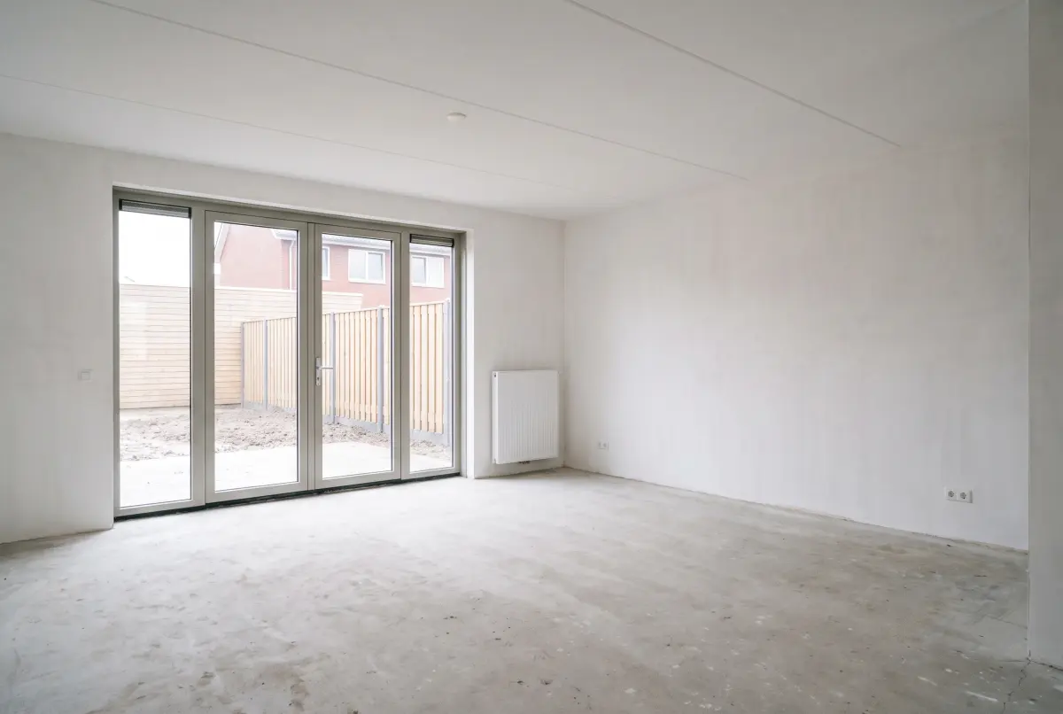 Een lege woonkamer zonder meubels, klaar om opnieuw in te richten